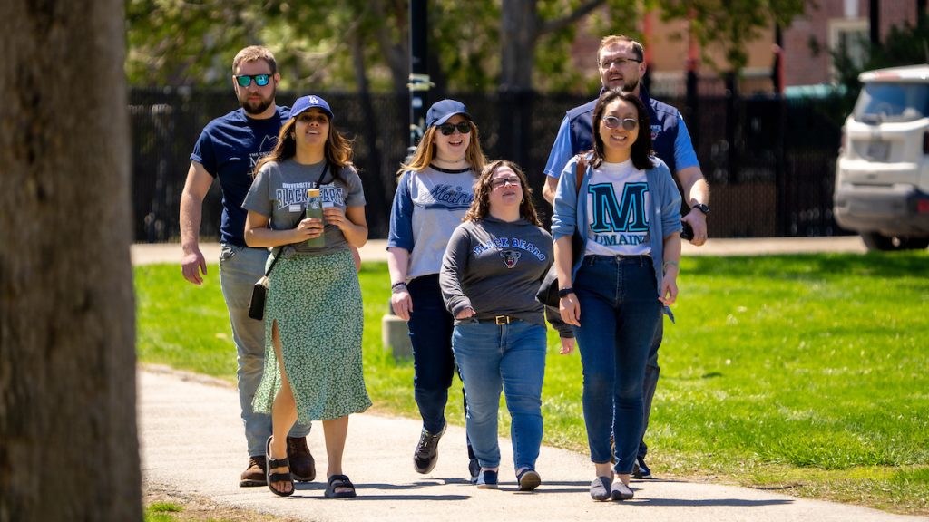 A photo of students walking along the UMaine mall.