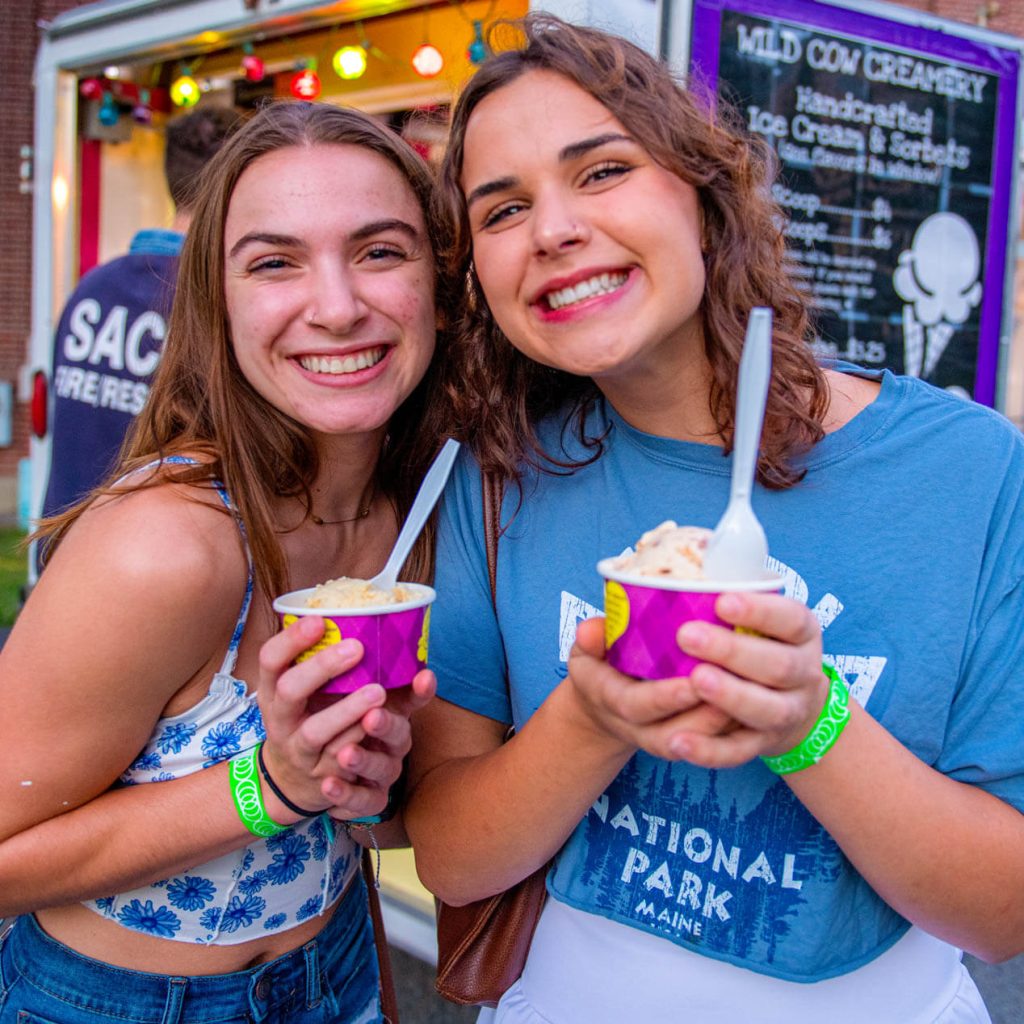 A photo of two people holding cups of ice cream