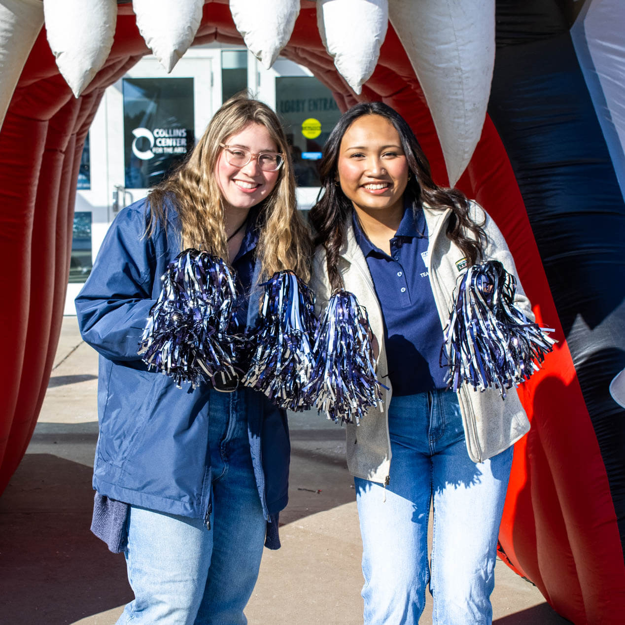 A photo of two people standing in front of an inflatable bear head