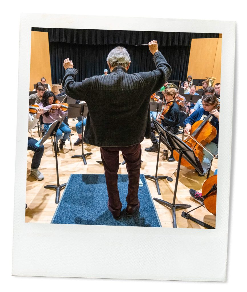 A photo of a music conductor in front of a student orchestra