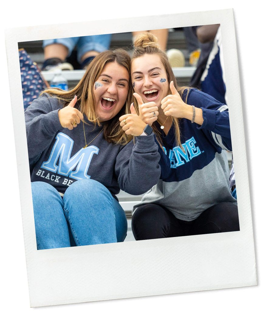 A photo of two women in the stands at a football game