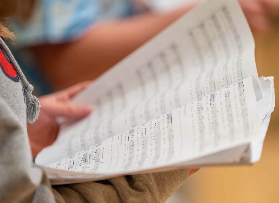 A photo of hands holding sheet music