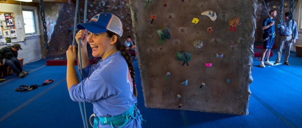 A photo of a person in front of an indoor climbing wall