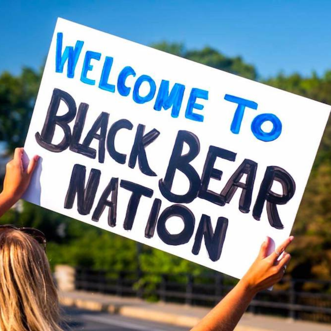 A photo of someone holding a "Welcome to Black Bear Nation" sign