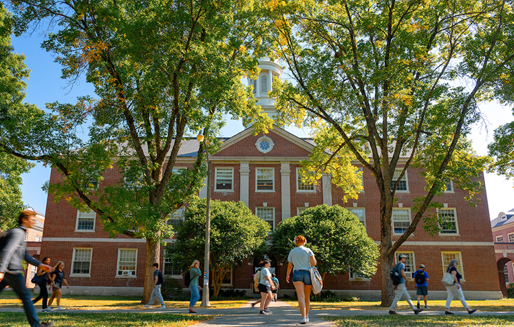 A photo of students walking along the UMaine mall