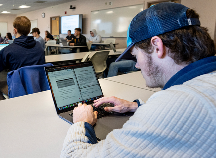 A photo of a student on his laptop